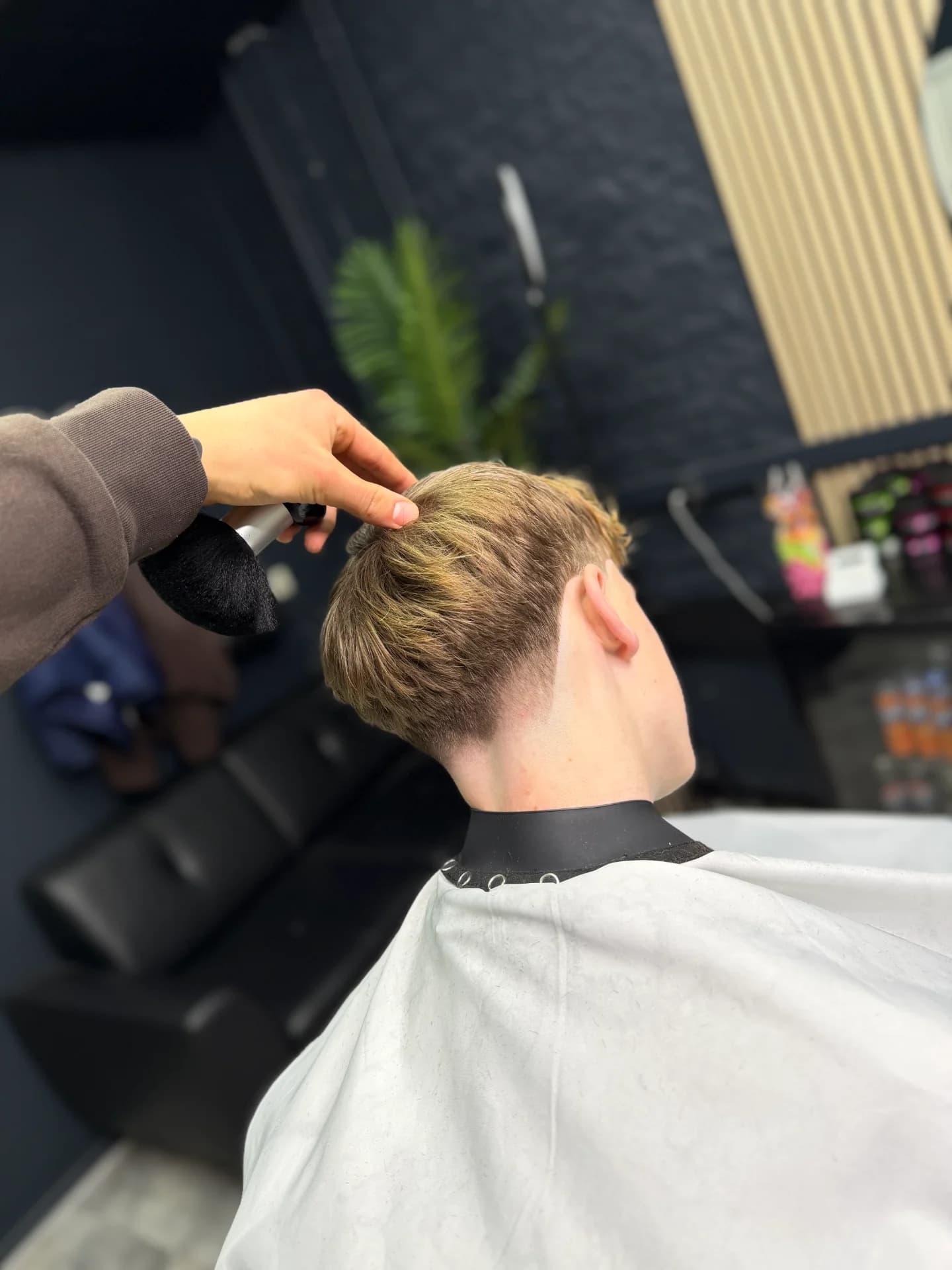 Professionele barbershop haircut met lage skin fade en scherpe hairline.