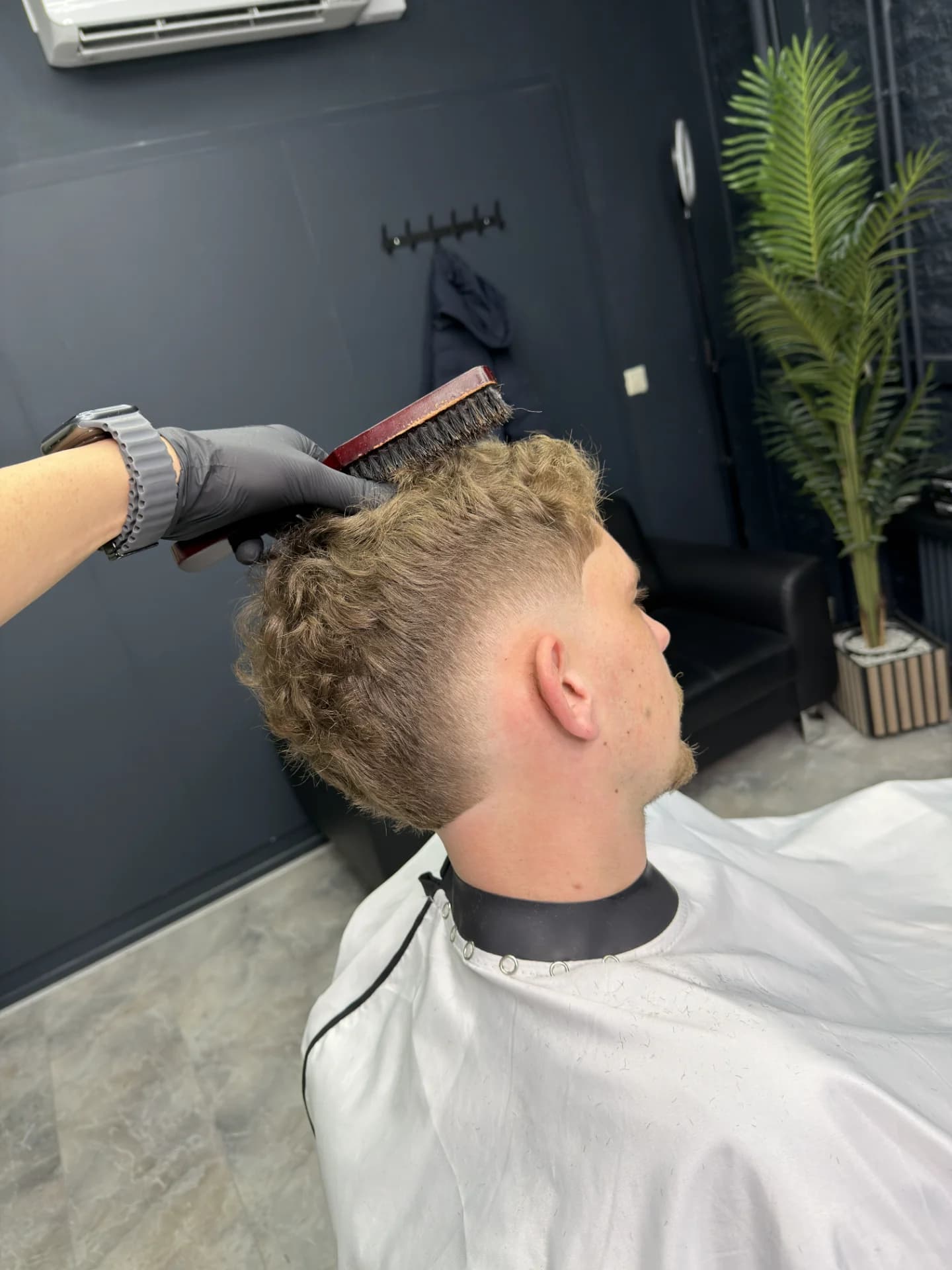 Professionele barbershop haircut met lage skin fade en scherpe hairline.